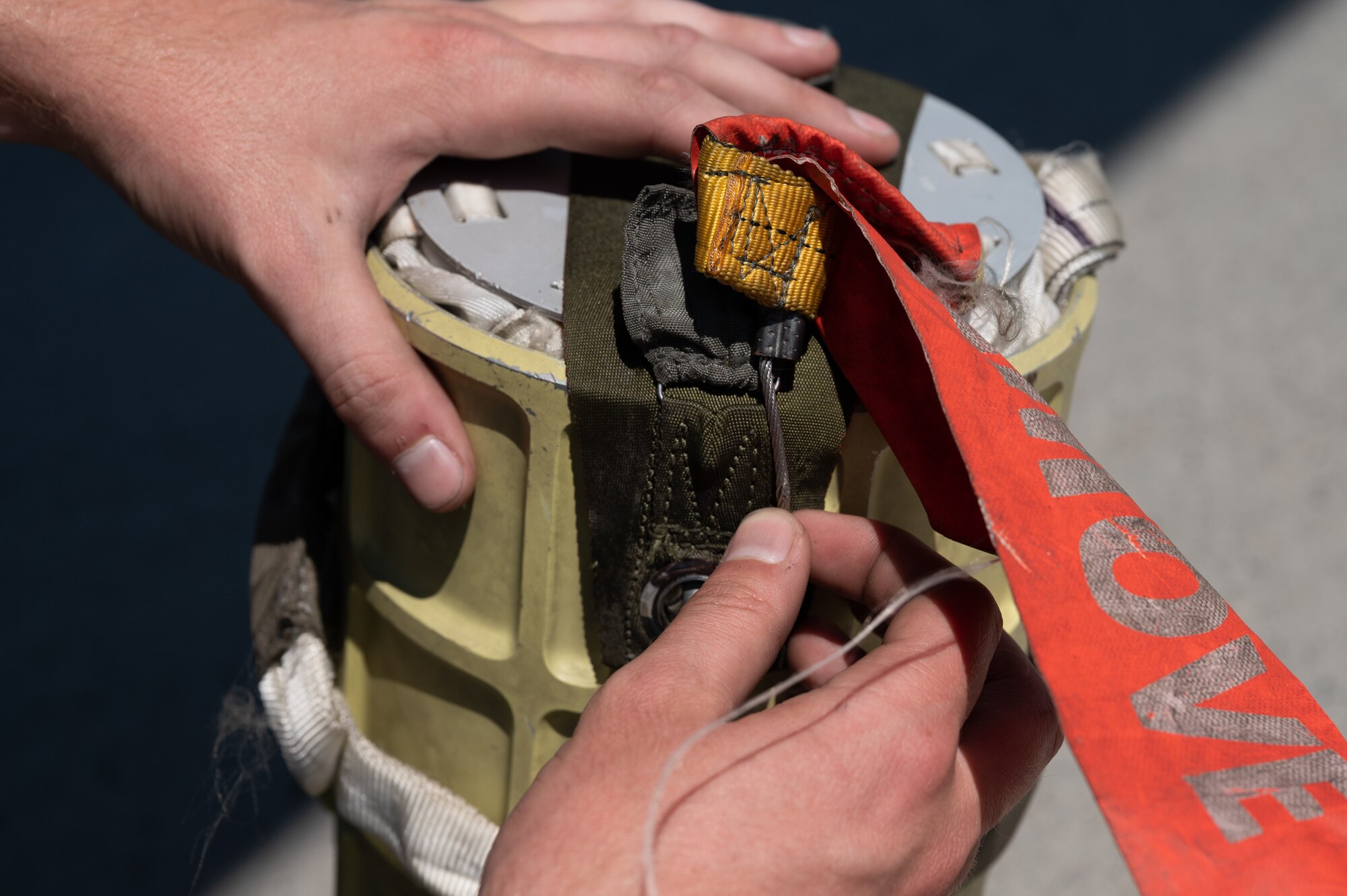 Airman 1st Class Jacob Kellet, 2nd Aircraft Maintenance Squadron, inspects the pin on a B-52H Stratofortress pilot chute during an Agile Combat Employment exercise at Fairchild Air Force Base, Washington Aug. 18, 2022. The pilot chute works with the main chute in a two-part system that decreases aircraft speed after landing. (U.S. Air Force photo by Senior Airman Chase Sullivan)