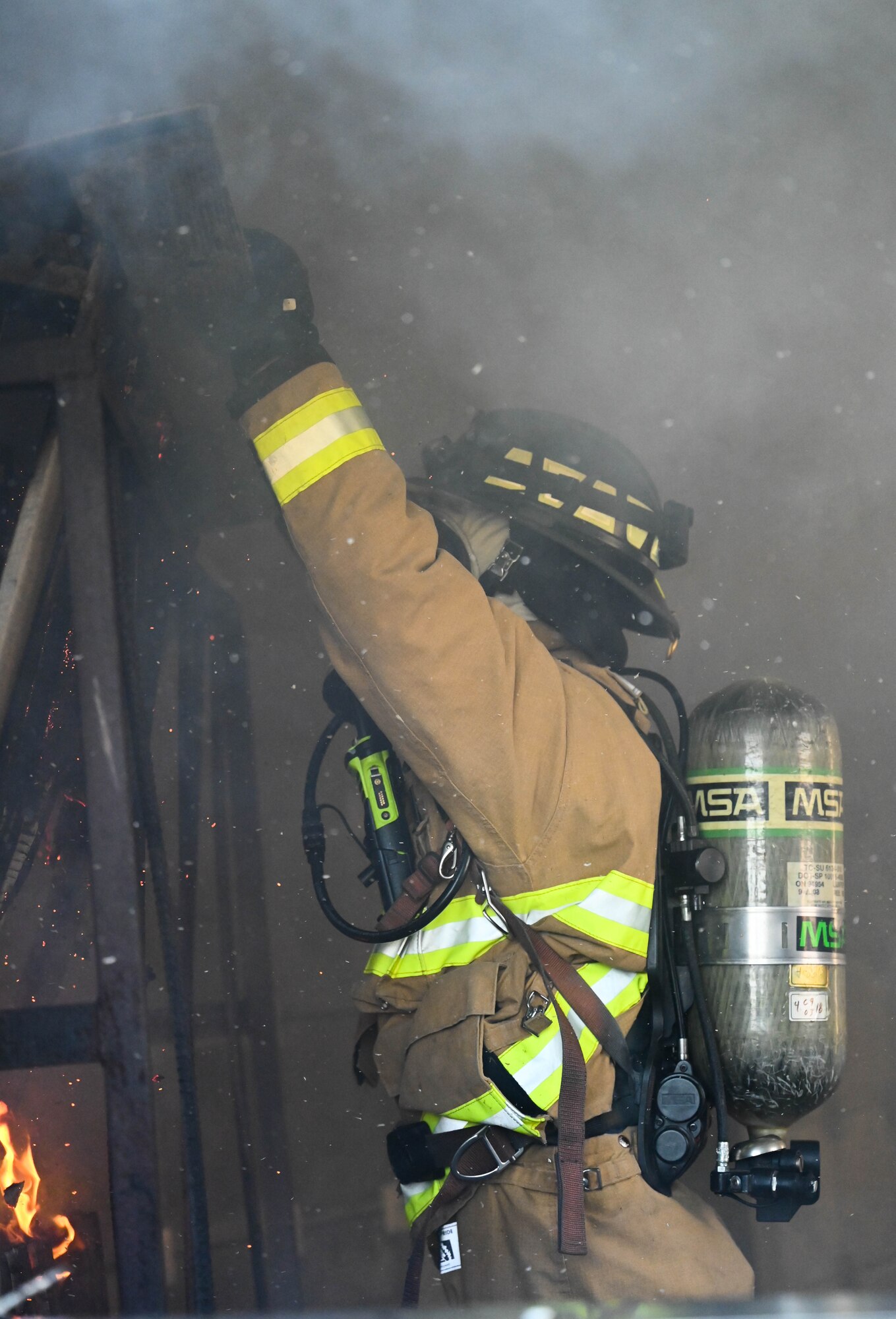 a man adds wood and paper to a fire.