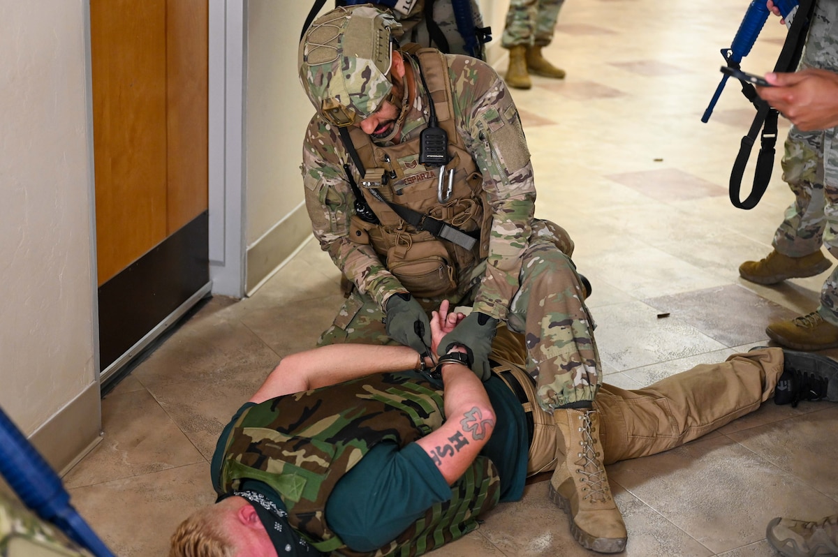 A photo of an Airman apprehending a simulated gunman.