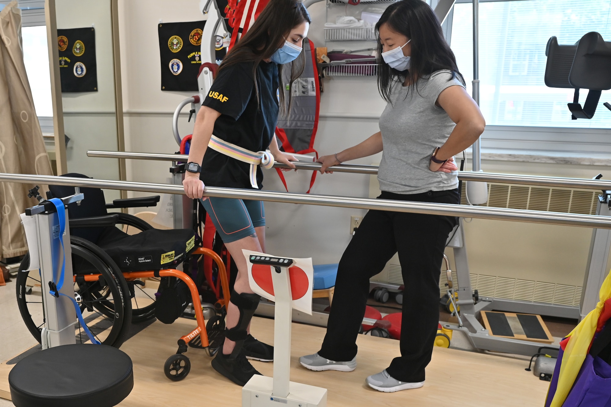 U.S. Air Force Airman 1st Class Lauren Arduser, 311th Training Squadron Russian language analyst, stands with the assistance of Physical Therapist, Amy Ikpeama, at the St. Louis VA Healthcare System-Jefferson Barracks, Missouri, August 18, 2022. The hospital services 70,000 veterans annually and underwent a multi-million dollar renovation that included five new buildings, showcasing state-of-the-art facilities. (U.S. Air Force photo by Senior Airman Abbey Rieves)