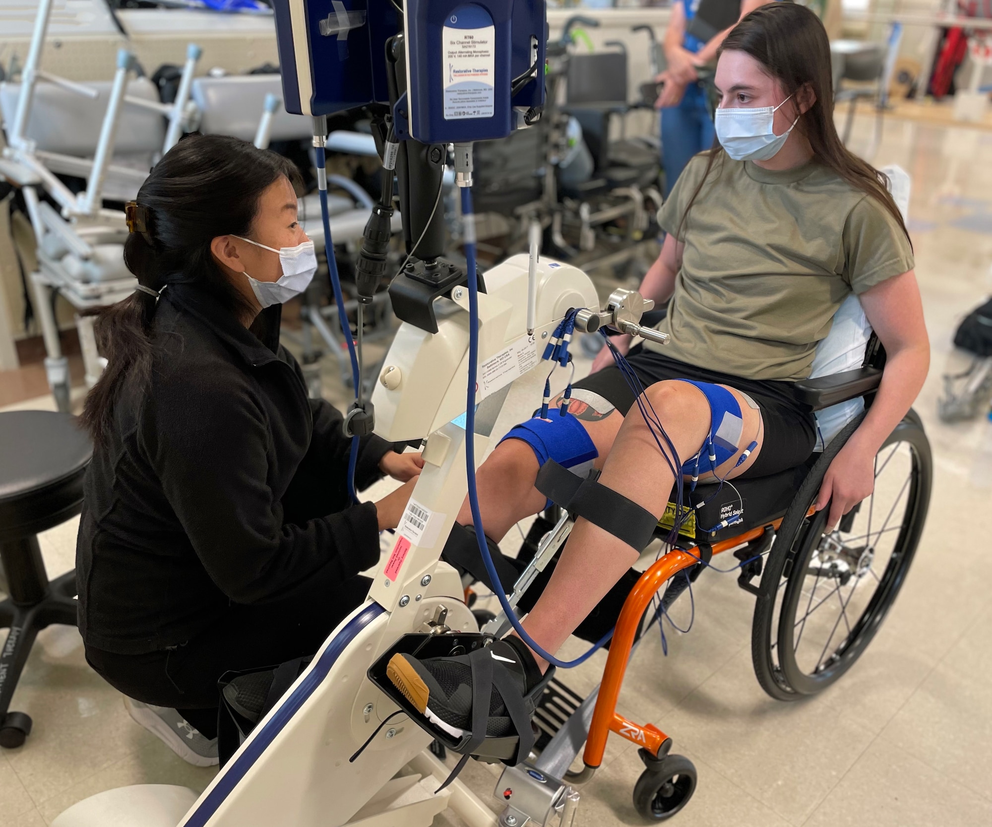 U.S. Air Force Airman 1st Class Lauren Arduser, 311th Training Squadron Russian language analyst, is connected to an RT300 by Physical Therapist, Amy Ikpeama, at the St. Louis VA Healthcare System-Jefferson Barracks, Missouri, August 18, 2022. Arduser suffered a spinal cord injury, which interrupted her brain’s ability to control her leg muscles. The RT300 sends manual electrical stimulation to power her leg muscle. (U.S. Air Force photo by Senior Airman Abbey Rieves)