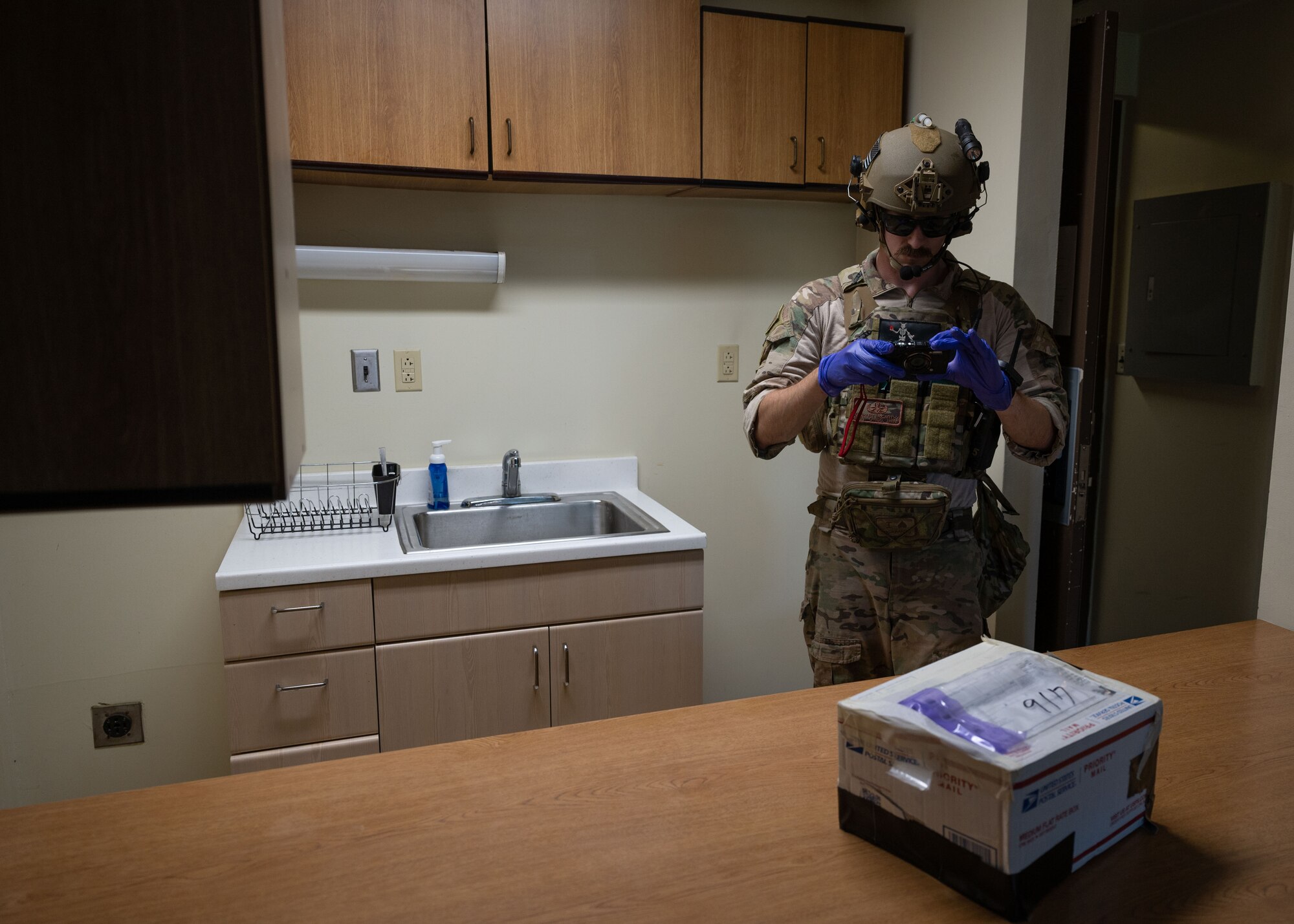An Airman takes a picture of the simulated explosive package.