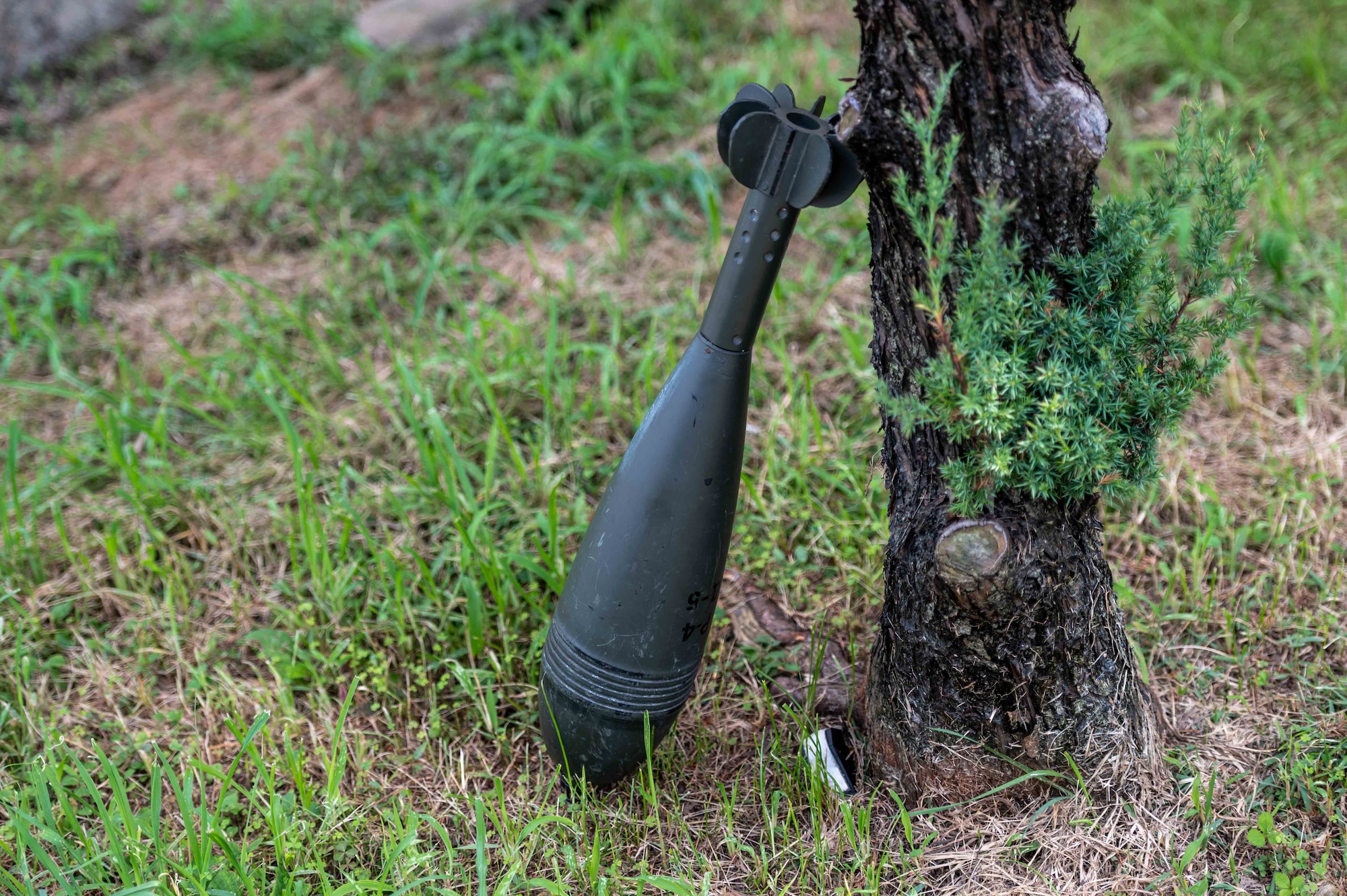 A simulated unexploded ordnance (UXO) leans against a tree as part of a base-wide training event at Osan Air Base