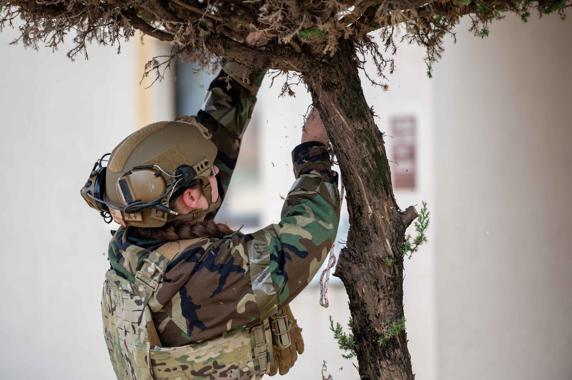 Senior Airman Janie Roberts, 51st Civil Engineer Squadron explosive ordnance disposal (EOD) team lead, attaches a rope and pulley to a tree branch above a simulated unexploded ordnance (UXO) during a base-wide training event at Osan Air Base