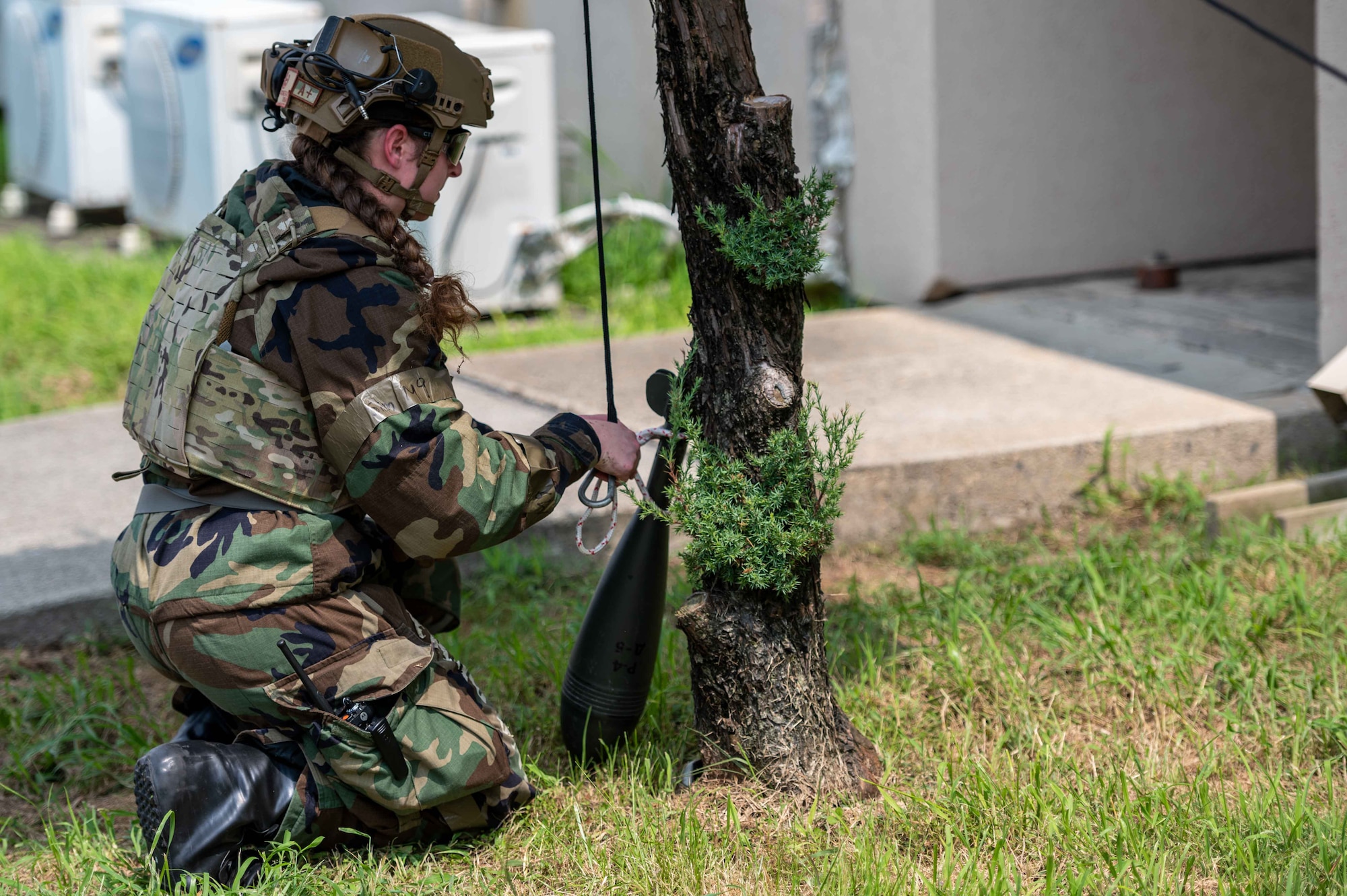 Senior Airman Janie Roberts, 51st Civil Engineer Squadron explosive ordnance disposal (EOD) team lead, attaches a rope and pulley to a simulated unexploded ordnance (UXO) during a base-wide training event at Osan Air Base
