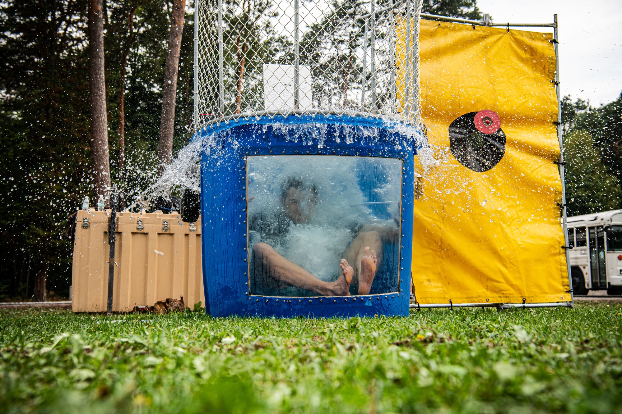 An Airman assigned to the 435th Air Ground Operations Wing falls into the dunk tank during a 435th AGOW Family Fun Event at Ramstein Air Base, Germany, Aug. 18, 2022. The day's activities included a bounce house, a dunk tank and water balloons. (U.S. Air Force photo by Airman 1st Class Jared Lovett)