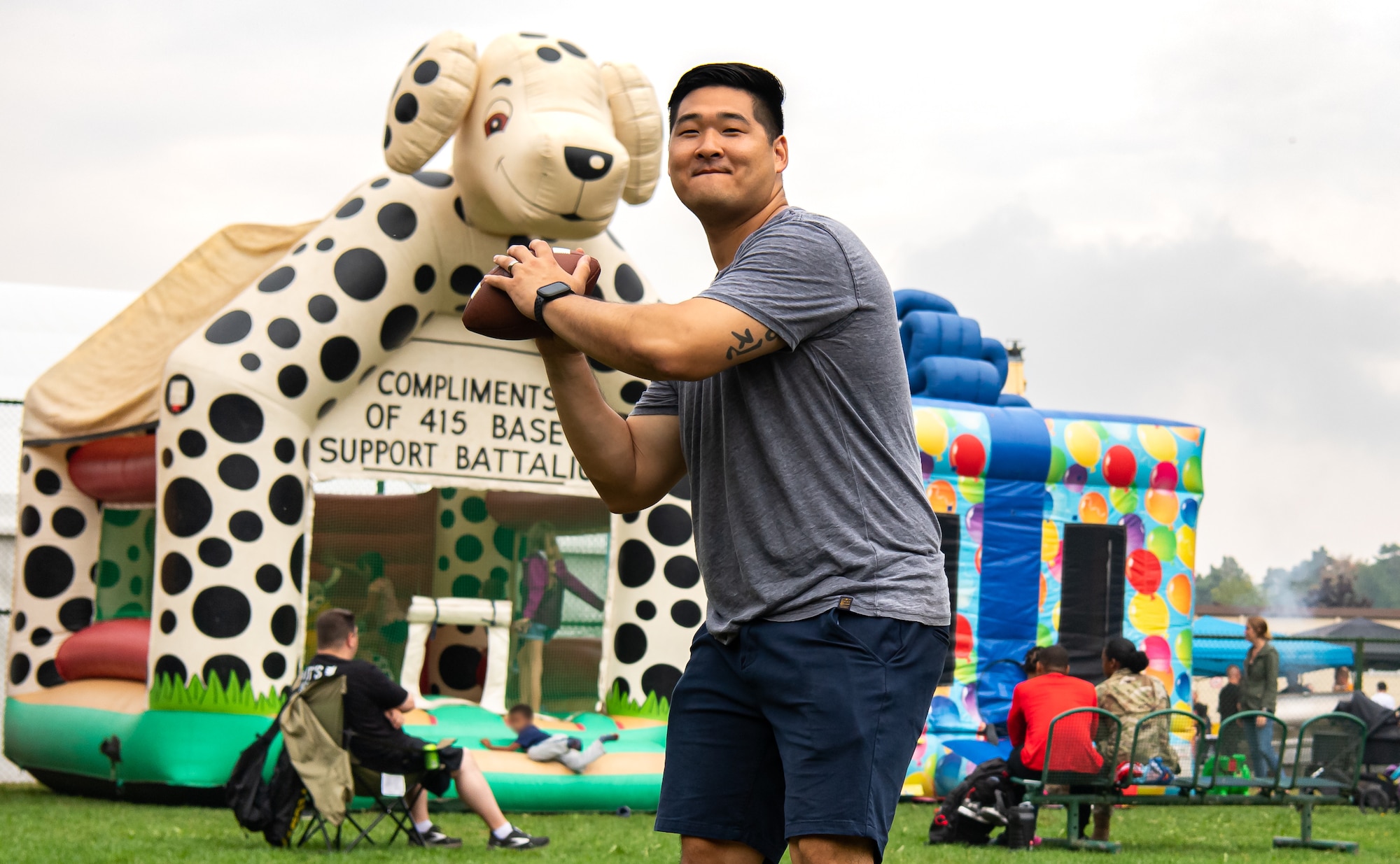 U.S. Air Force Maj. Jonathan Han, 435th Air Ground Operations Wing  Plans and Programs chief, plays football with friends and family during a 435th AGOW Family Fun Event at Ramstein Air Base, Germany, Aug. 18, 2022. Airmen from across the wing were able to enjoy a day of food and fellowship with their peers. (U.S. Air Force photo by Airman 1st Class Jared Lovett)