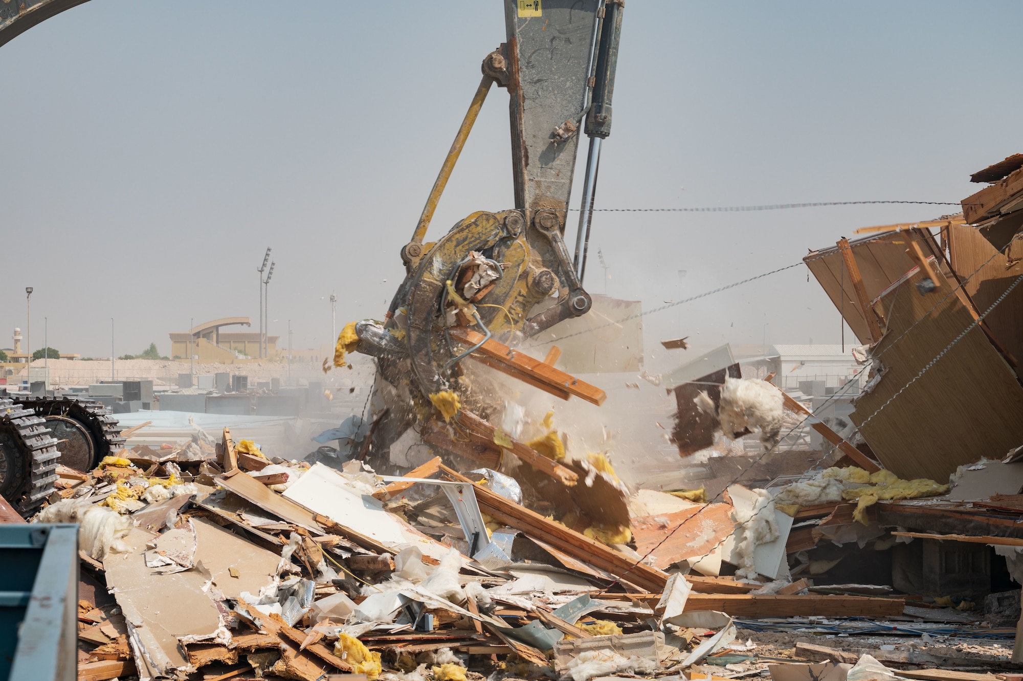 A trailer is pulled apart by an excavator during demolition on Aug. 22, 2022 at Al Udeid Air Base, Qatar. This project was approved and contracted in mid-2021 and is set to conclude Dec. 2022. (U.S. Air Force photo by Staff Sgt. Dana Tourtellotte)