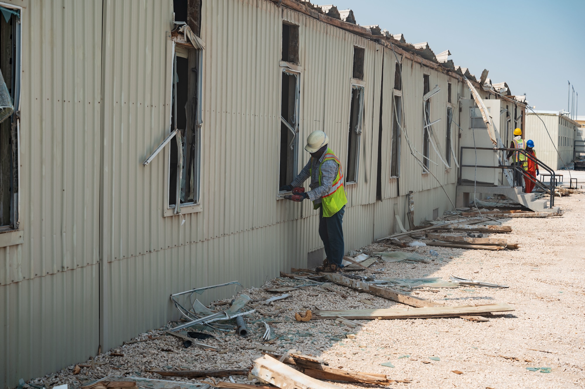 Piece by piece, trailers are demolished to make room for new and lasting facilities at Al Udeid Air Base, Qatar, Aug. 22, 2022. The newly available space will allow for a new Coalition Compound gym facility as well as other renovations. (U.S. Air Force photo by Staff Sgt. Dana Tourtellotte)