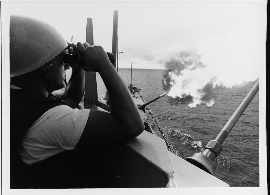 John A. Sharp watches for enemy shore battery gunfire as the USS NEWPORT NEWS (CA-148) blasts the enemy targets with her big 8-inch/55 caliber rapid-fire guns, 11 October 1967.