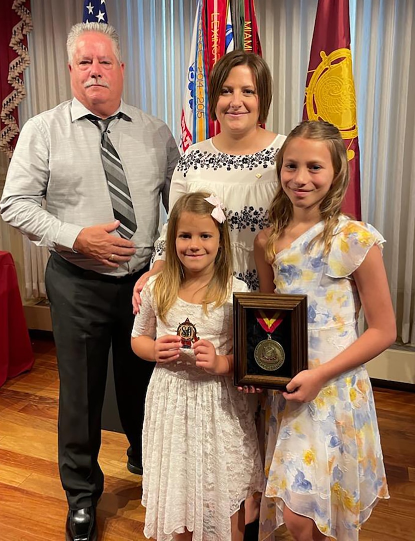 Sgt. 1st Class Terry Jones II’s daughters, Candace and Evelyn, spouse Amy, and father retired Sgt. 1st Class Terry Jones, Sr., accept Jones’ U.S. Army Transportation Corps Hall of Fame induction award during the ceremony July 29 at Fort Lee, Virginia.