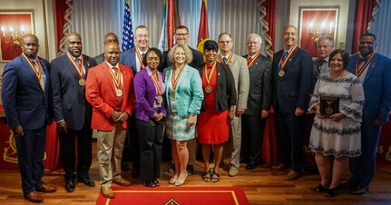 Amy Jones, spouse of Sgt. 1st Class Terry Jones II, and retired Sgt. 1st Class Terry Jones, Sr., Jones’ father, join with other 2022 Transportation Corps Hall of Fame inductees July 29 at Fort Lee, Virginia. Jones was among 22 Transportation Corps Soldiers and Civilians inducted into the Hall of Fame, and one of two inducted posthumously.