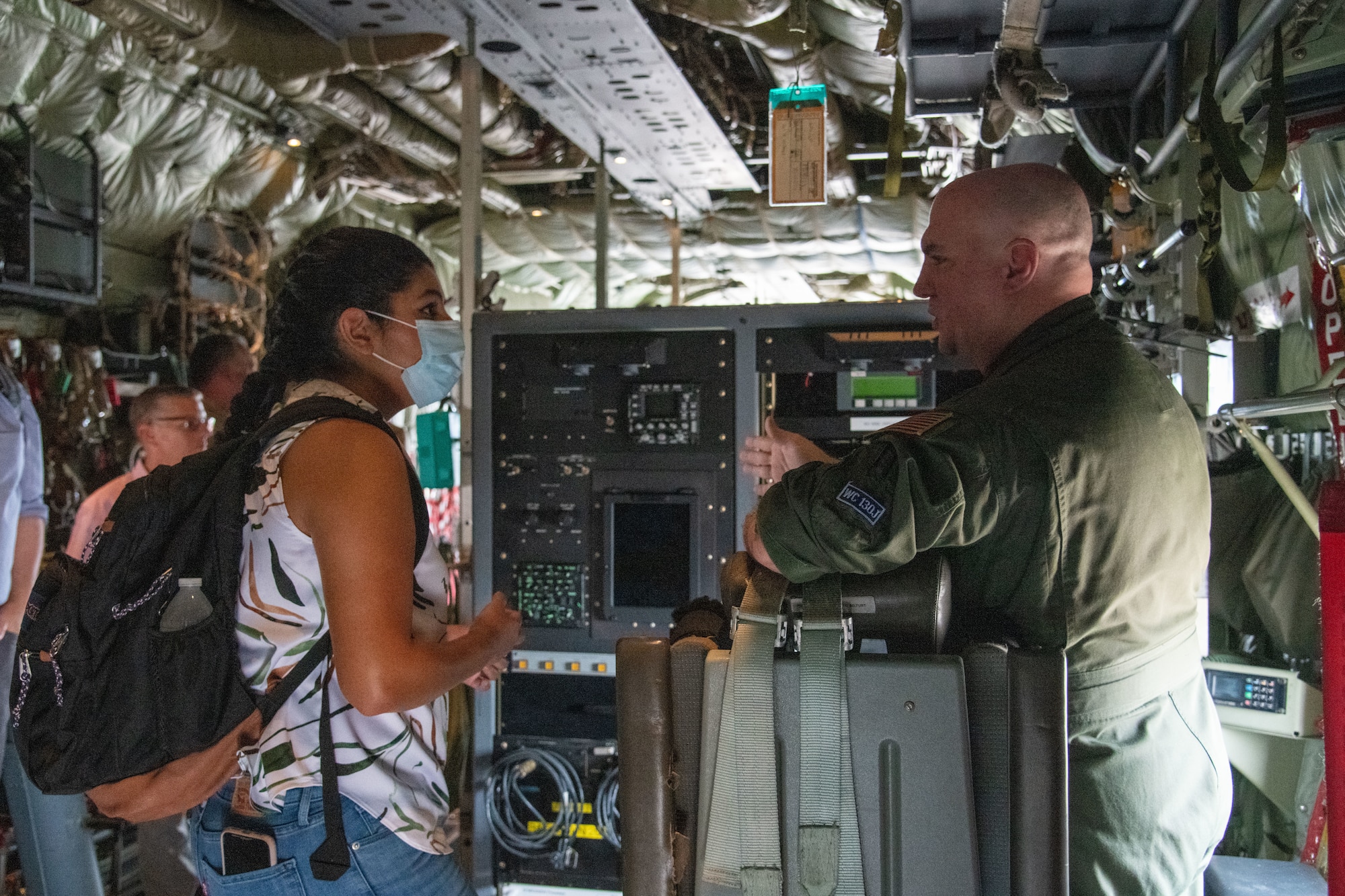 A staffer listens as Lt. Col. Tobi Baker tells her about the weather pallet on a WC-130J