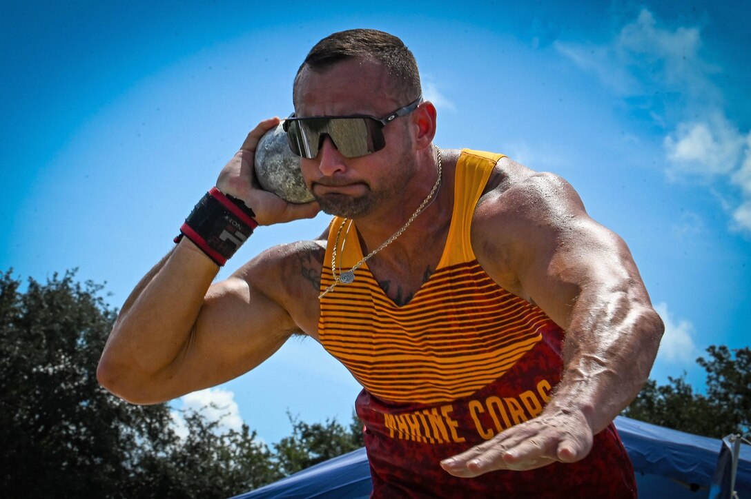 An athlete winds up to throw a ball outdoors.