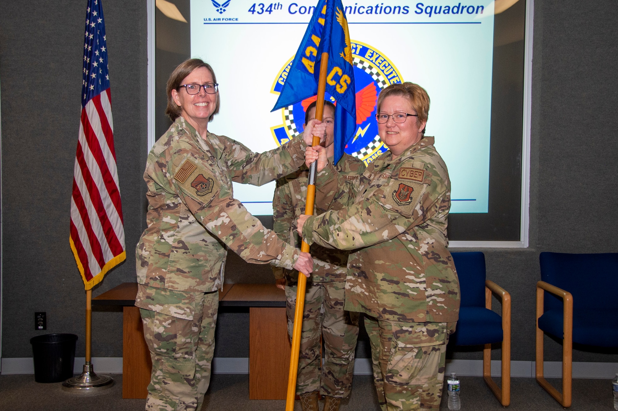 Col. Gretchen Wiltse, 434th Mission Support Group commander, hands the 434th Communications Squadron guidon to Lt. Col. Gwendoyln Fulton during an assumption of command ceremony at Gus Grissom Hall, Aug. 6, 2022. The passing of the guidon represents a transfer of responsibility and authority of a unit from one leader to the next. (U.S. Air Force photo by Staff Sgt. Michael Hunsaker)