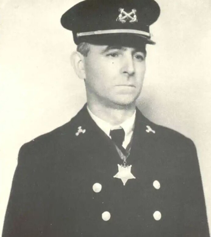 A man in a uniform wears a medal around his neck.