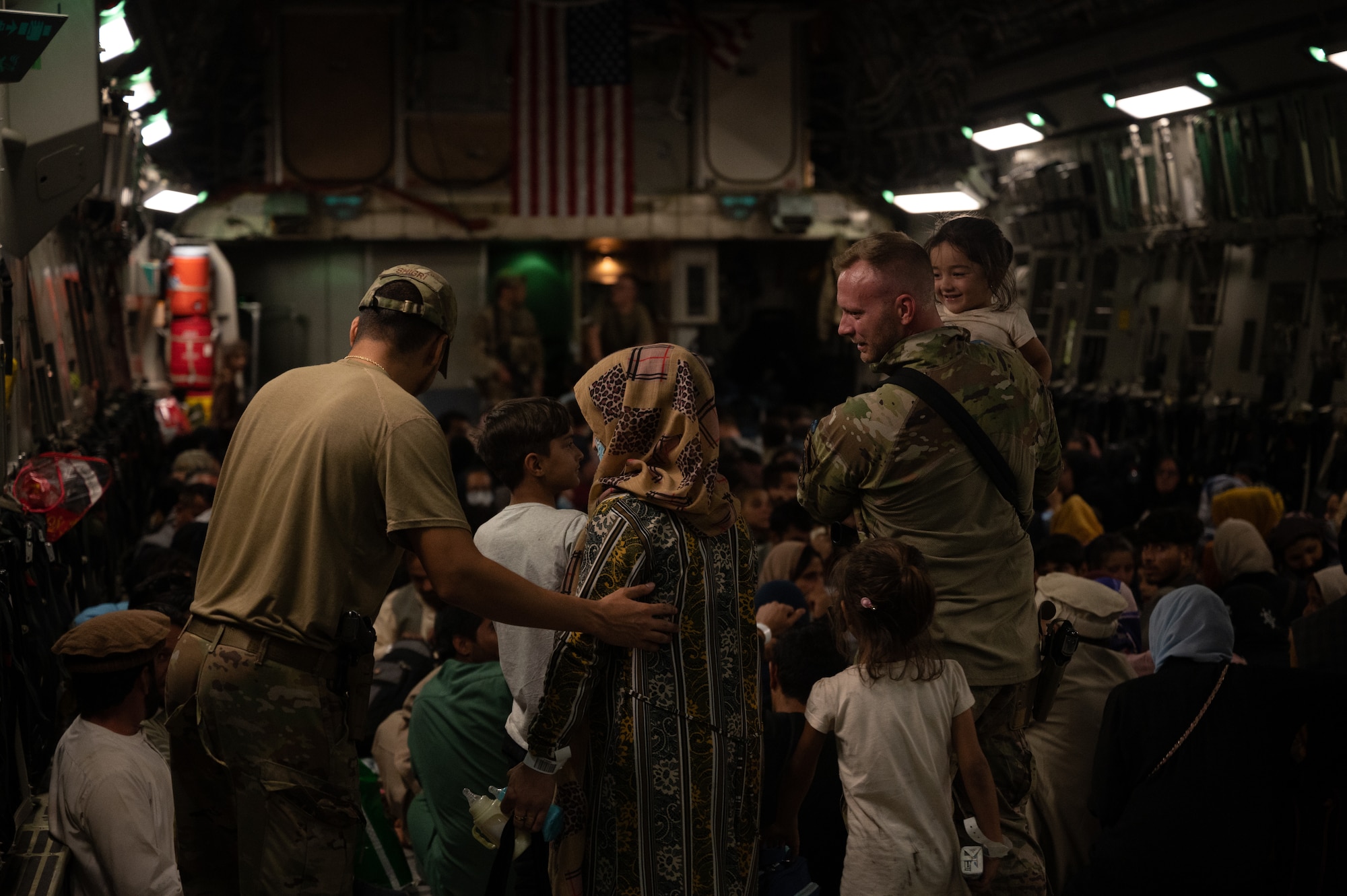 A U.S. Air Force Airman assists an Afghan citizen aboard a C-17 Globemaster III during Operation Allies Refuge, Aug. 19, 2021. Approximately 124,000 Afghan citizens were evacuated from Kabul, Afghanistan, during OAR, one of the largest air evacuations of civilians in American history. (U.S. Air Force photo by Staff Sgt. Brandon Cribelar)