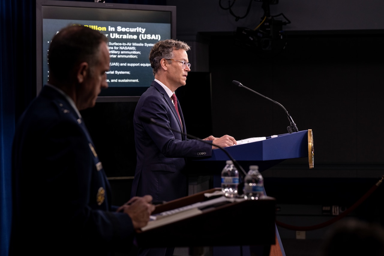 Two men speak from podiums.