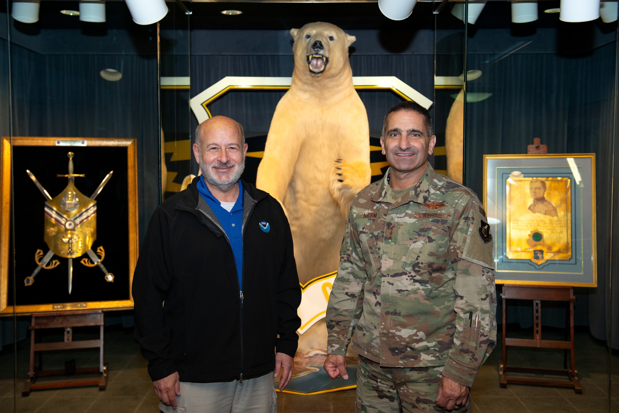 Photo of U.S. Air Force Lt. Gen. David Nahom and Richard “Rick” Spinrad posing for a photo in front of a stuffed polar bear display