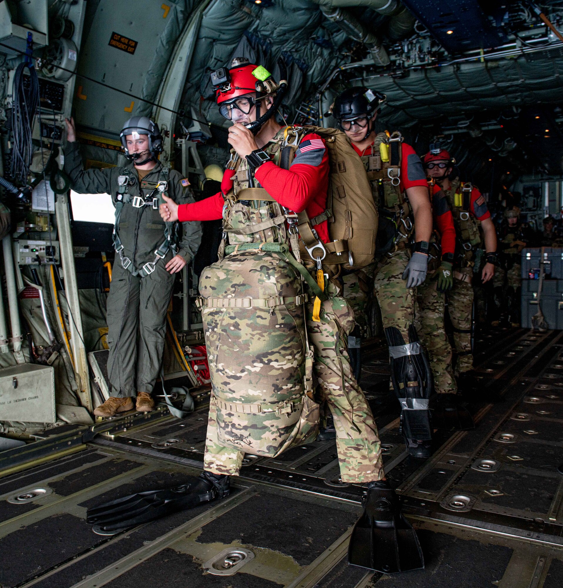 A bunch of Air Force personnel prepare jump out of the jet and into the water