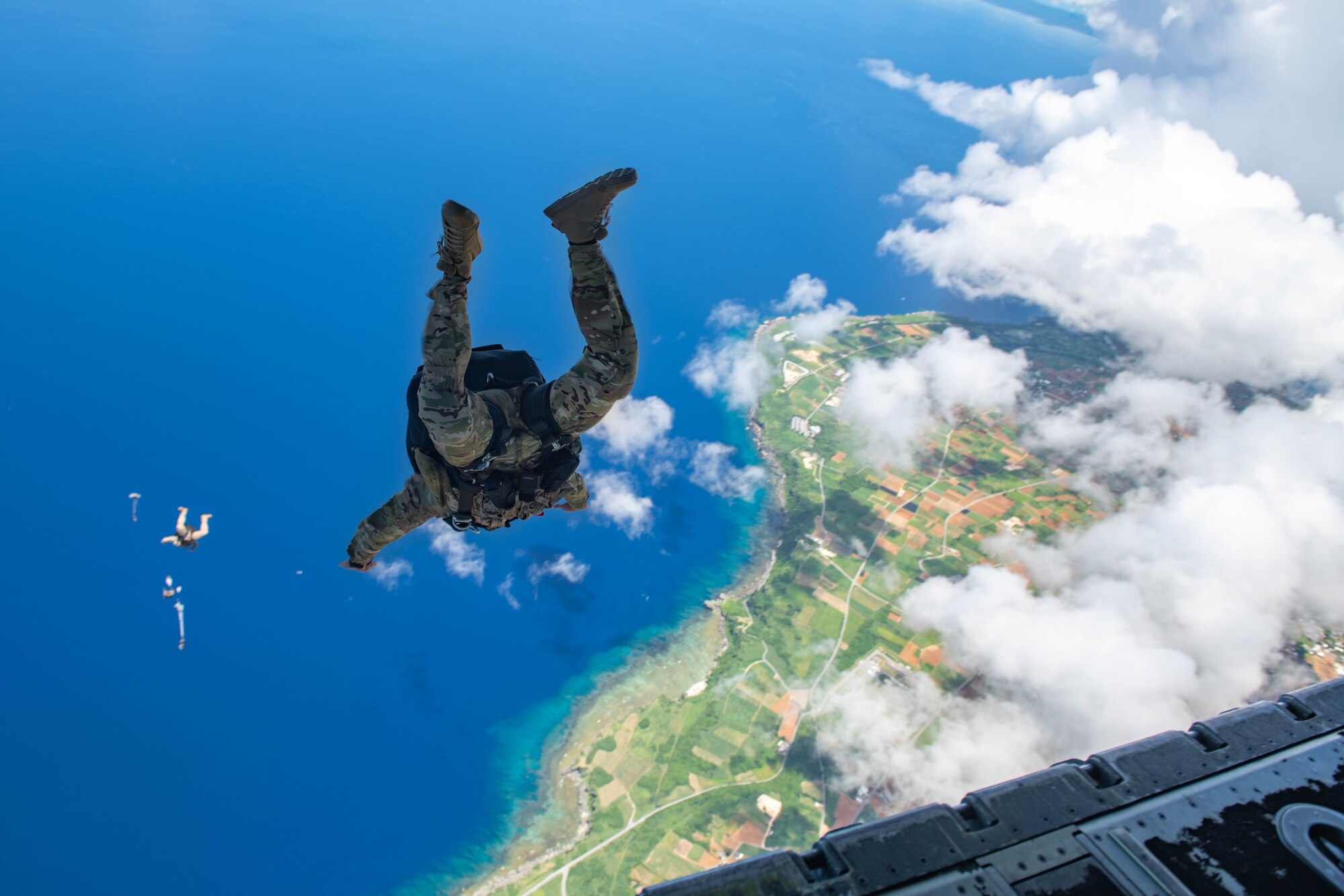 A Navy member flies after his fellow jumpers as they release their parachutes.