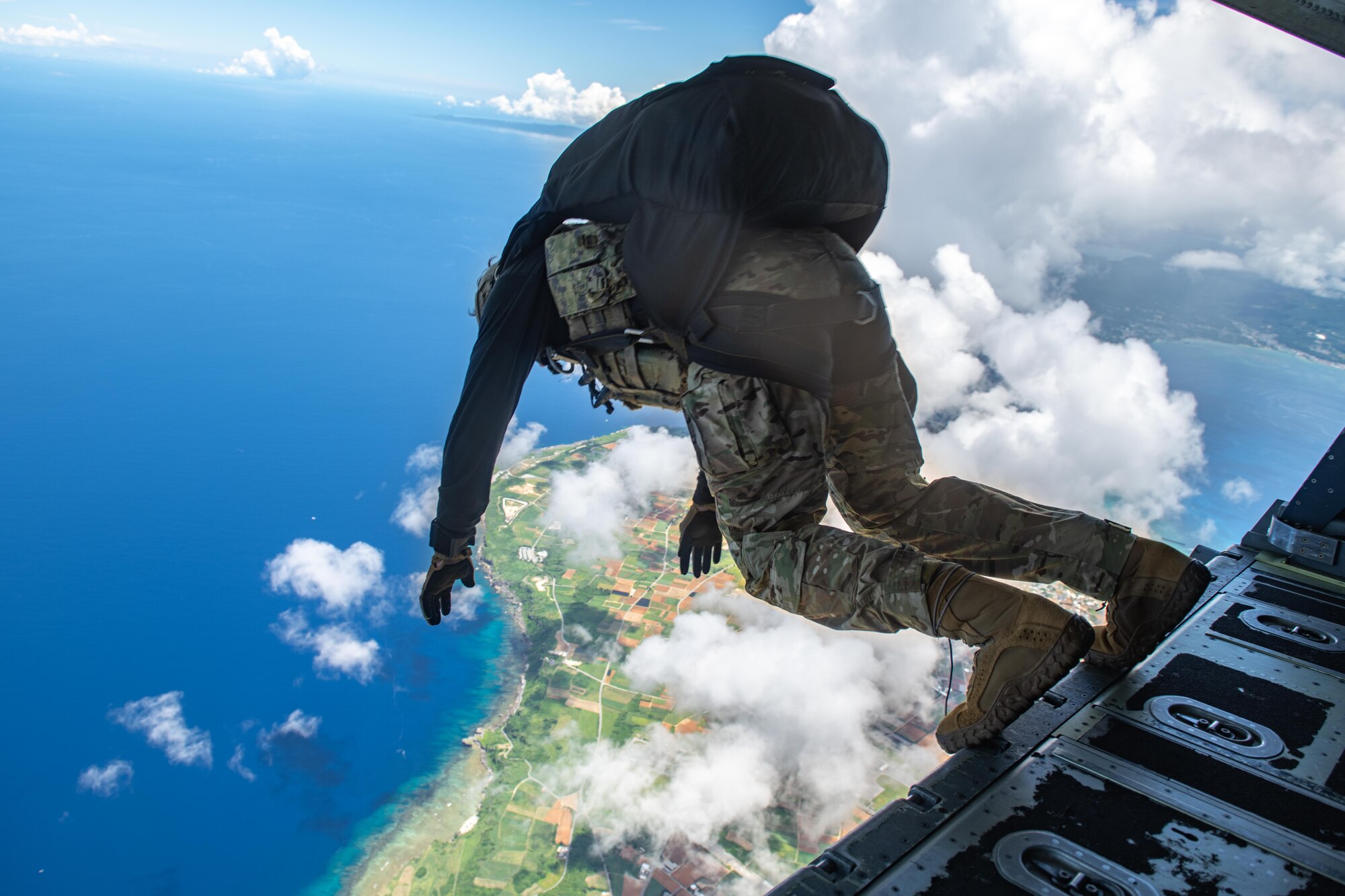 A Navy member prepares to jump from the back of a plane