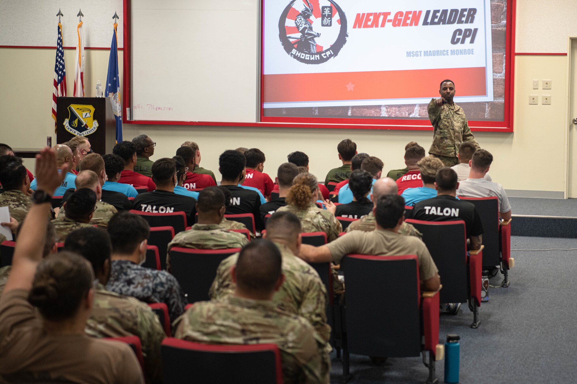 An Airman calls on an audience member to answer a question.