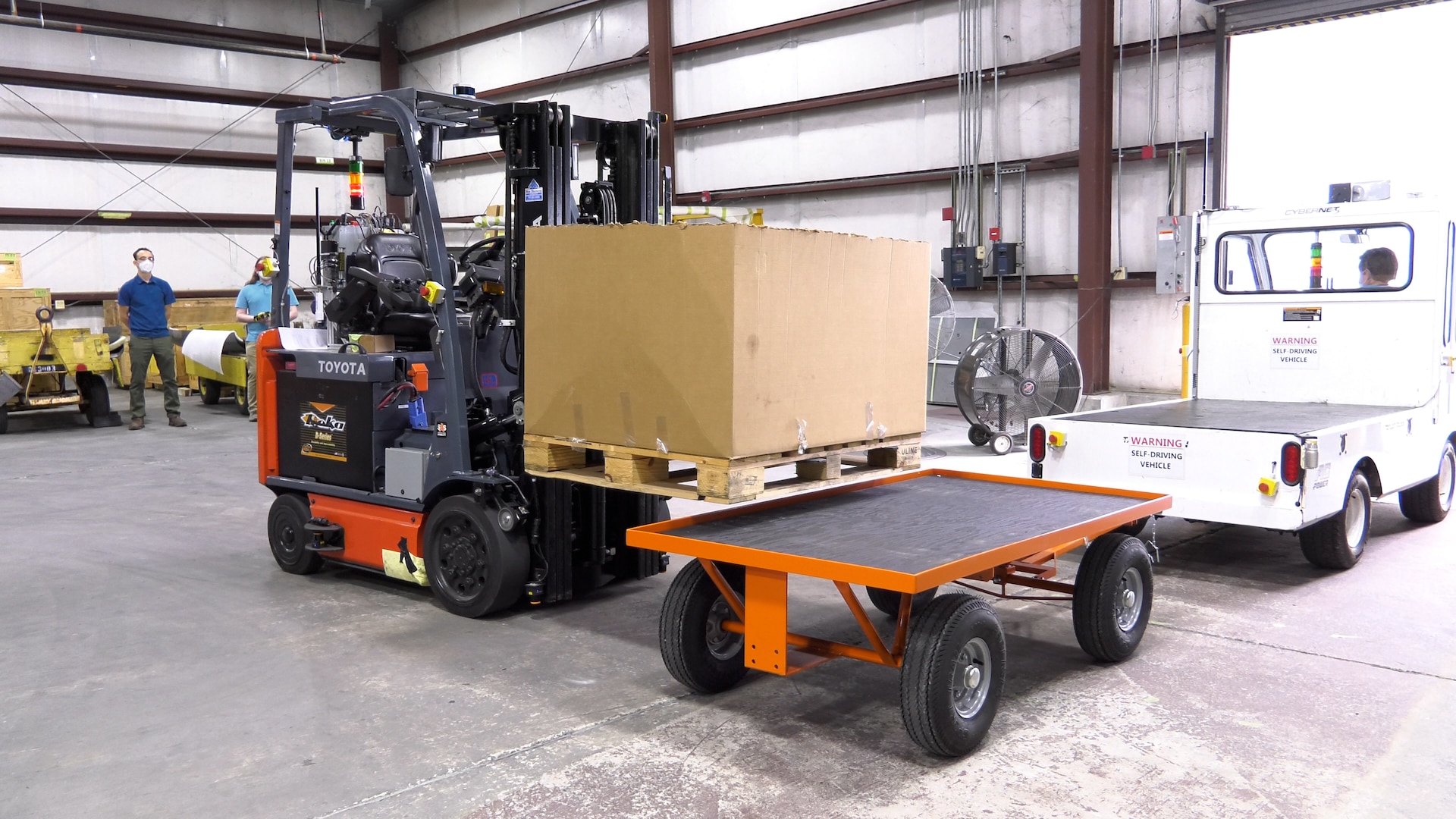 Forklift places crate on parts cart.