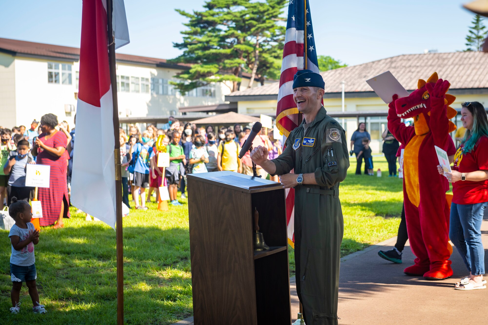 military member in uniform give a speech at a podium in front of a crowd.