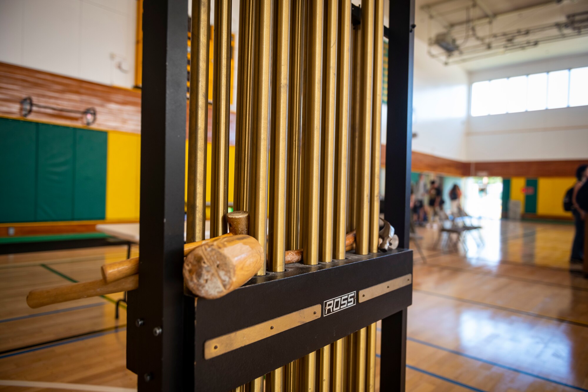 A set of mallets and tubular bells instrument sit in a gym