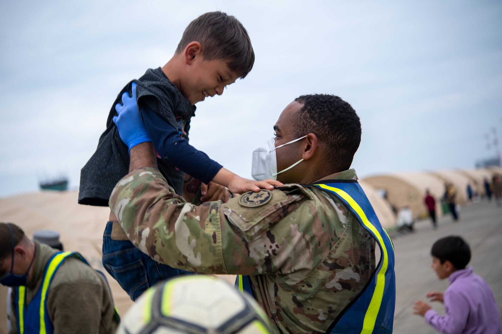 U.S. Army Pfc. Jared Stevens, 2nd Cavalry Regiment infantryman, plays with children during Operation Allies Refuge at Ramstein Air Base, Germany, Sept. 13, 2021. OAR has been the largest humanitarian evacuation airlift to date in U.S. history. (U.S. Air Force photo by Airman 1st Class Alexcia Givens)