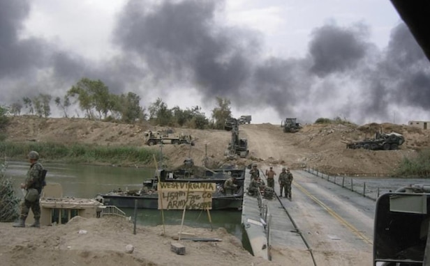 Soldiers from the 459th Engineer Company (Multi-role Bridge Company), based in Bridgeport, West Virginia and U.S. Marines construct a float bridge over the Diyala River in Iraq on April 7, 2003.