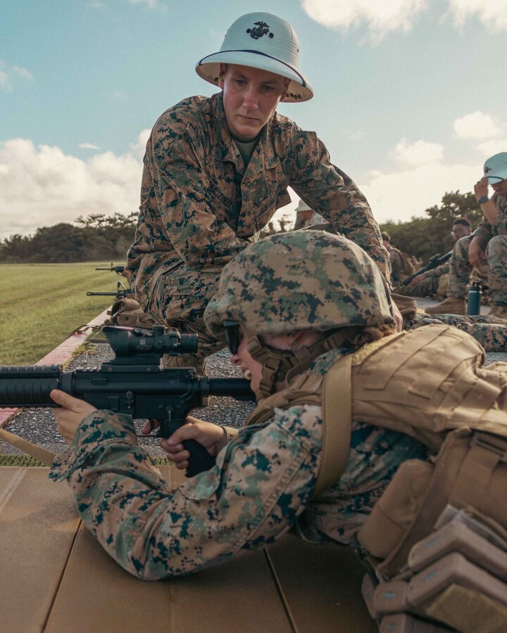 U.S. Marine Corps Cpl. Brian Omalleymolk, a marksmanship instructor with Headquarters and Support Battalion, Marine Corps Installations Pacific, coaches a Marine about their body positioning during the Annual Rifle Qualification on Camp Hansen, Okinawa, Japan, Aug. 2, 2022. The Marine Corps implemented the new ARQ 10 months ago to replace the Annual Rifle Training. During the new ARQ, Marines use the standing, kneeling, and prone positions with artificial support to simulate realistic shooting positions in combat, improving proficiency as riflemen. (U.S. Marine Corps photo by Lance Cpl. Jonathan Beauchamp)