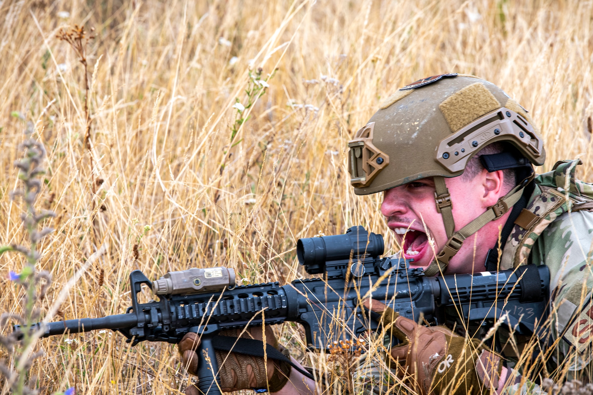 U.S. Air Force Senior Airman Ambrose Ross, 423d Security forces squadron police services, relays commands during a field training exercise at Stanford Training Area, England, Aug. 17, 2022. Instructors from the 820th Base Defense Group and 435th Security Forces Squadron Ground Combat Readiness Training Center, conducted the exercise to evaluate and bolster the combat readiness skills of the defenders from the 423d SFS. (U.S. Air Force photo by Staff Sgt. Eugene Oliver)
