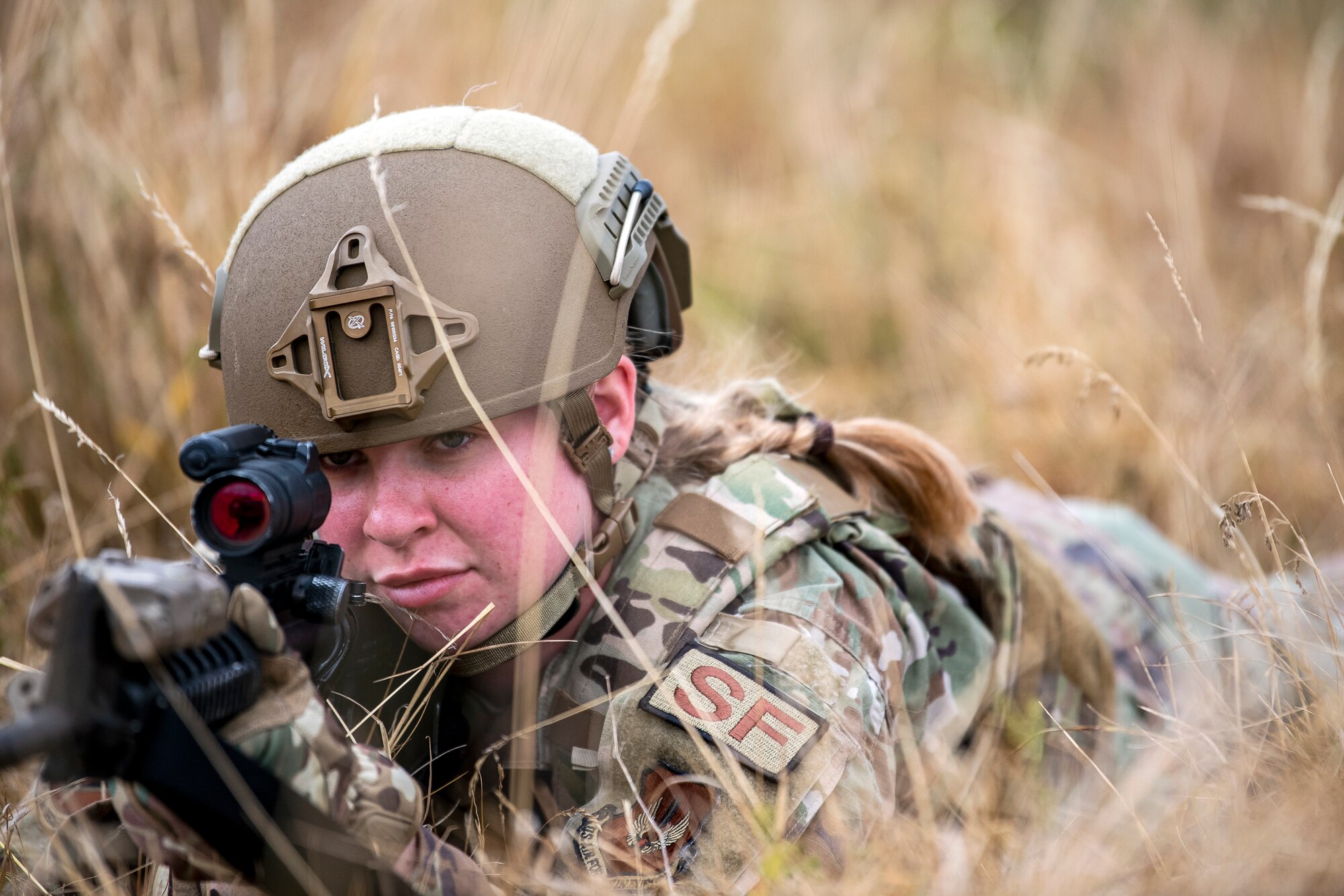U.S. Air Force Airman 1st Class Sierra Capobianco, 423d Security Forces Squadron base defense operations center controller, looks down the sight of an M4 carbine during a field training exercise at Stanford Training Area, England, Aug. 17, 2022. Instructors from the 820th Base Defense Group and 435th Security Forces Squadron Ground Combat Readiness Training Center, conducted the exercise to evaluate and bolster the combat readiness skills of the defenders from the 423d SFS. (U.S. Air Force photo by Staff Sgt. Eugene Oliver)