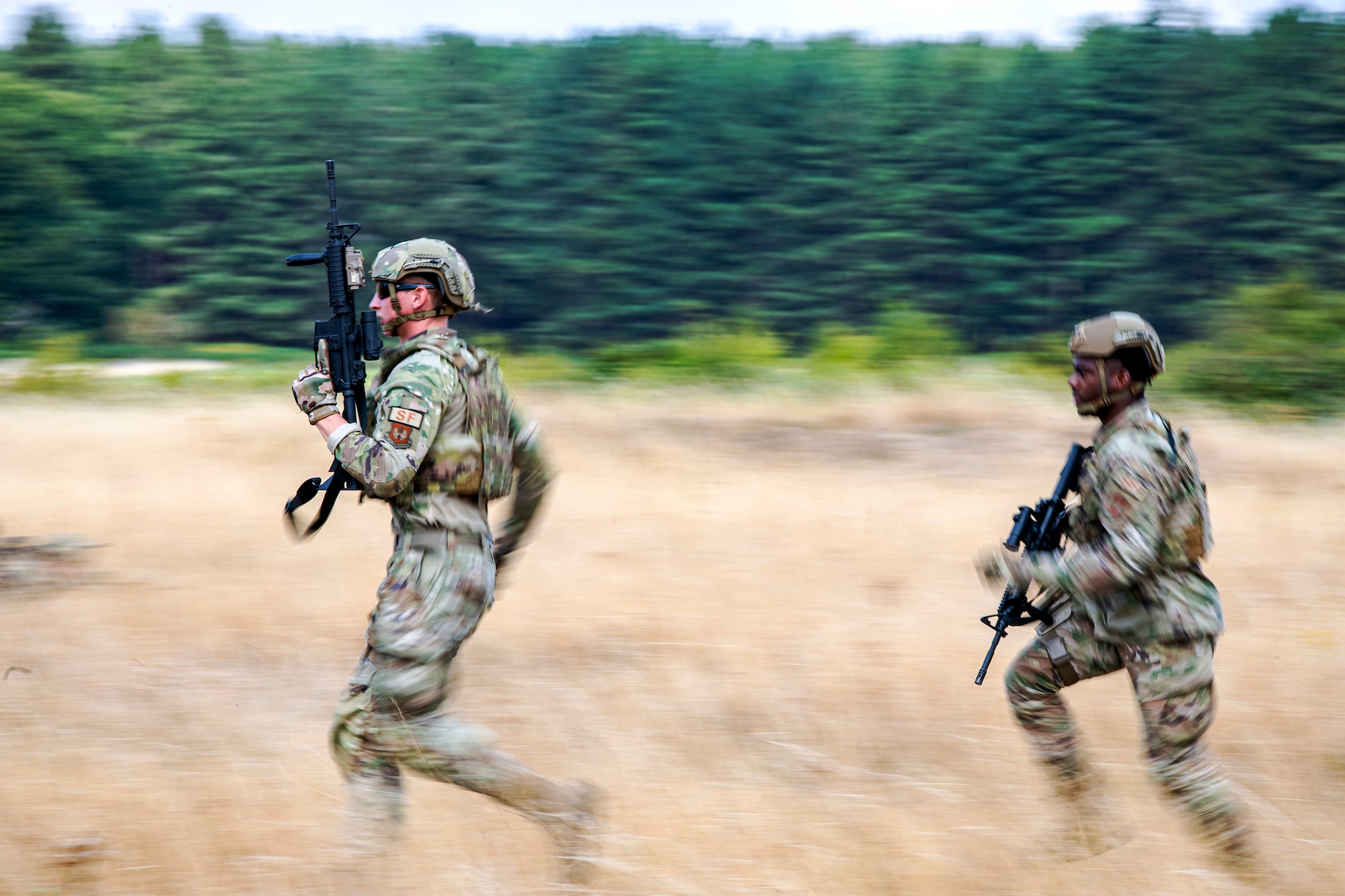 Airmen from the 423d Security Forces Squadron advance their position during a field training exercise at Stanford Training Area, England, Aug. 17, 2022. Instructors from the 820th Base Defense Group and 435th Security Forces Squadron Ground Combat Readiness Training Center, conducted the exercise to evaluate and bolster the combat readiness skills of the defenders from the 423d SFS. (U.S. Air Force photo by Staff Sgt. Eugene Oliver)