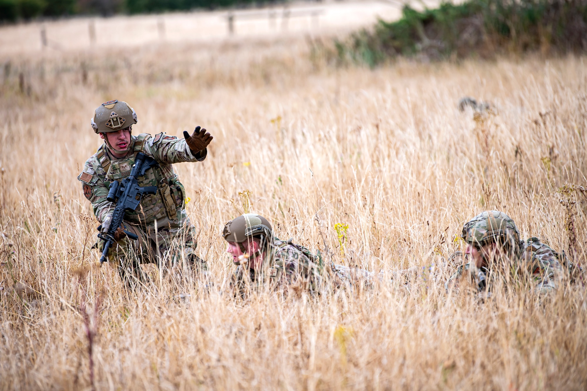 U.S. Air Force Senior Airman Ambrose Ross, left, 423d Security Forces Squadron police services, relays a command to Airmen from the 423d SFS, during a field training exercise at Stanford Training Area, England, Aug. 17, 2022. Instructors from the 820th Base Defense Group and 435th Security Forces Squadron Ground Combat Readiness Training Center, conducted the exercise to evaluate and bolster the combat readiness skills of the defenders from the 423d SFS. (U.S. Air Force photo by Staff Sgt. Eugene Oliver)