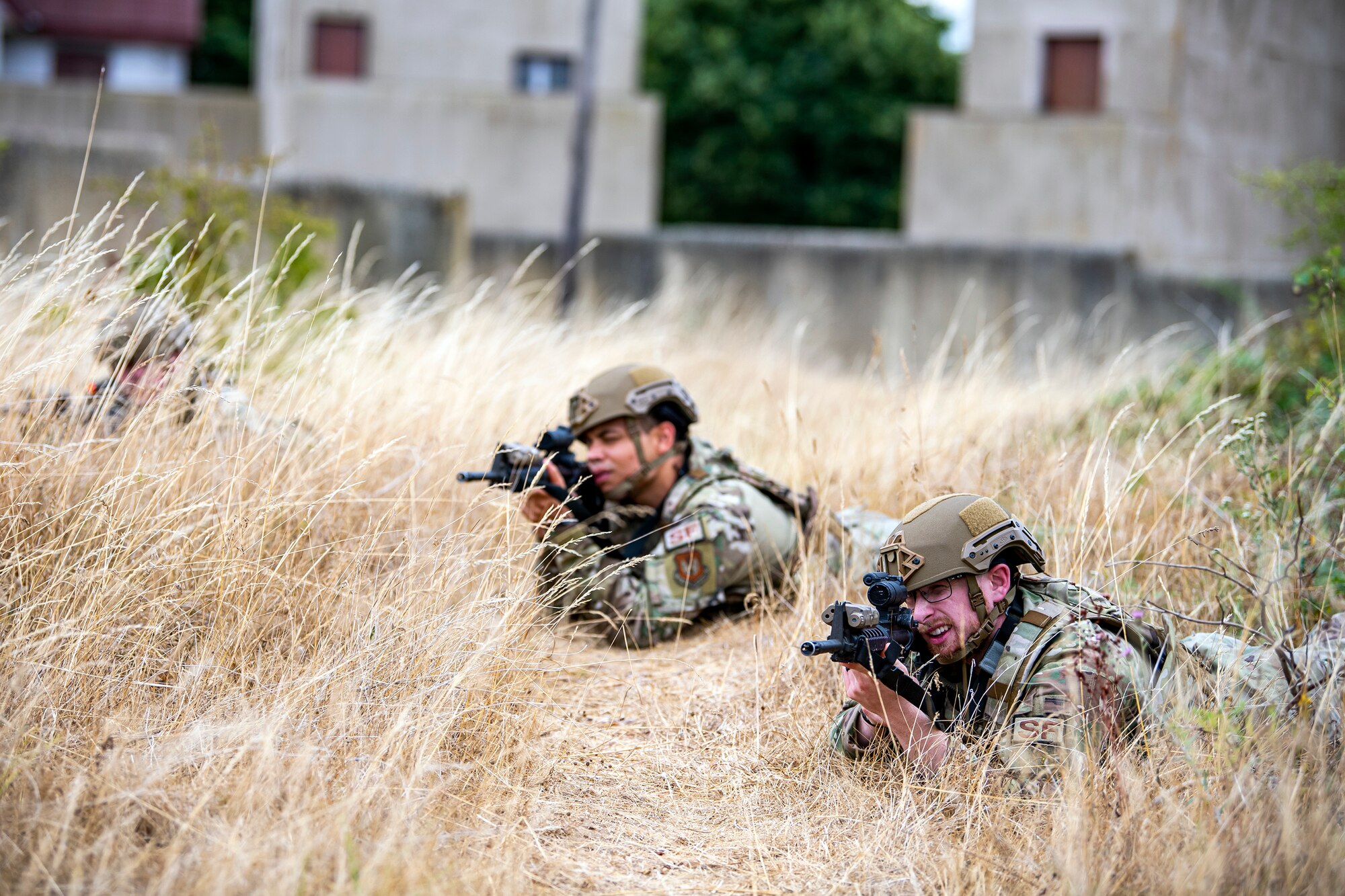 Airmen from the 423d Security Forces Squadron lay prone while looking down the sights of their M4 carbines during a field training exercise at Stanford Training Area, England, Aug. 17, 2022. Instructors from the 820th Base Defense Group and 435th Security Forces Squadron Ground Combat Readiness Training Center, conducted the exercise to evaluate and bolster the combat readiness skills of the defenders from the 423d SFS. (U.S. Air Force photo by Staff Sgt. Eugene Oliver)