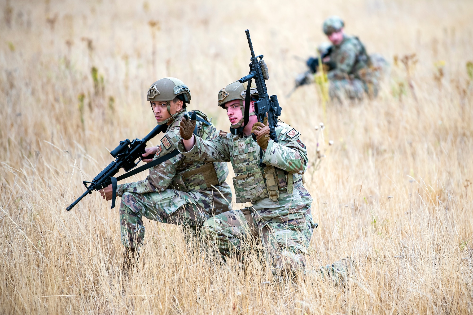 U.S. Air Force Senior Airman Ambrose Ross, foreground right, 423d Security Forces Squadron police services, speaks with Airman 1st Class Daniel Richards, 423d SFS entry control operator, during a field training exercise at Stanford Training Area, England, Aug. 17, 2022. Instructors from the 820th Base Defense Group and 435th Security Forces Squadron Ground Combat Readiness Training Center, conducted the exercise to evaluate and bolster the combat readiness skills of the defenders from the 423d SFS. (U.S. Air Force photo by Staff Sgt. Eugene Oliver)