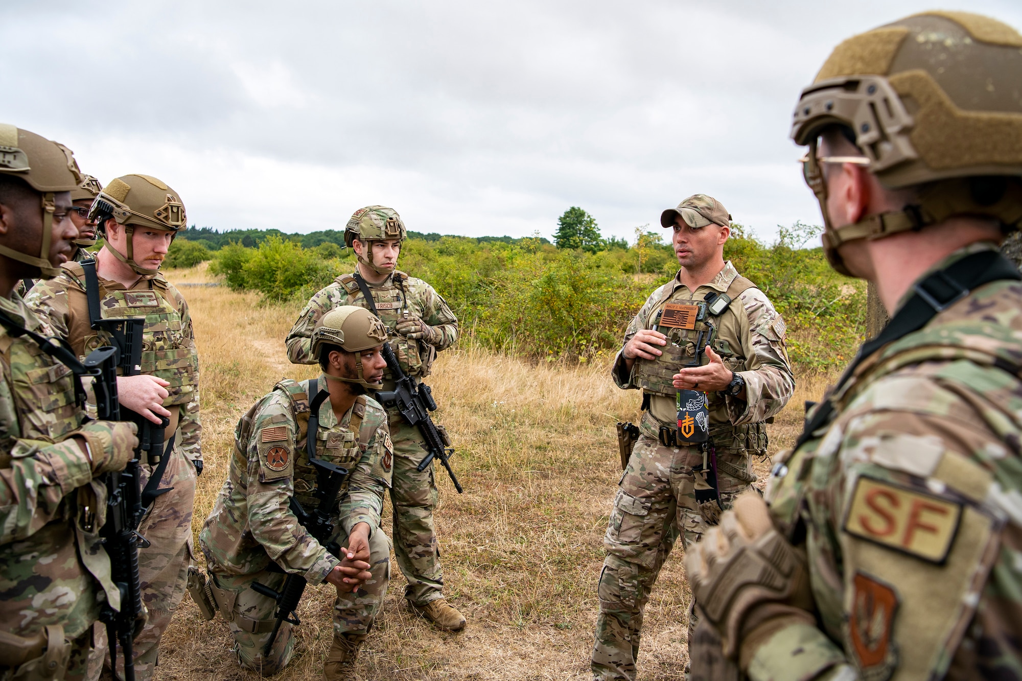 U.S. Air Force Staff Sgt. James Matherly, center right, 824th Base Defense Squadron squad leader, gives instruction during a field training exercise at Stanford Training Area, England, Aug. 17, 2022. Instructors from the 820th Base Defense Group and 435th Security Forces Squadron Ground Combat Readiness Training Center, conducted the exercise to evaluate and bolster the combat readiness skills of the defenders from the 423d SFS. (U.S. Air Force photo by Staff Sgt. Eugene Oliver)