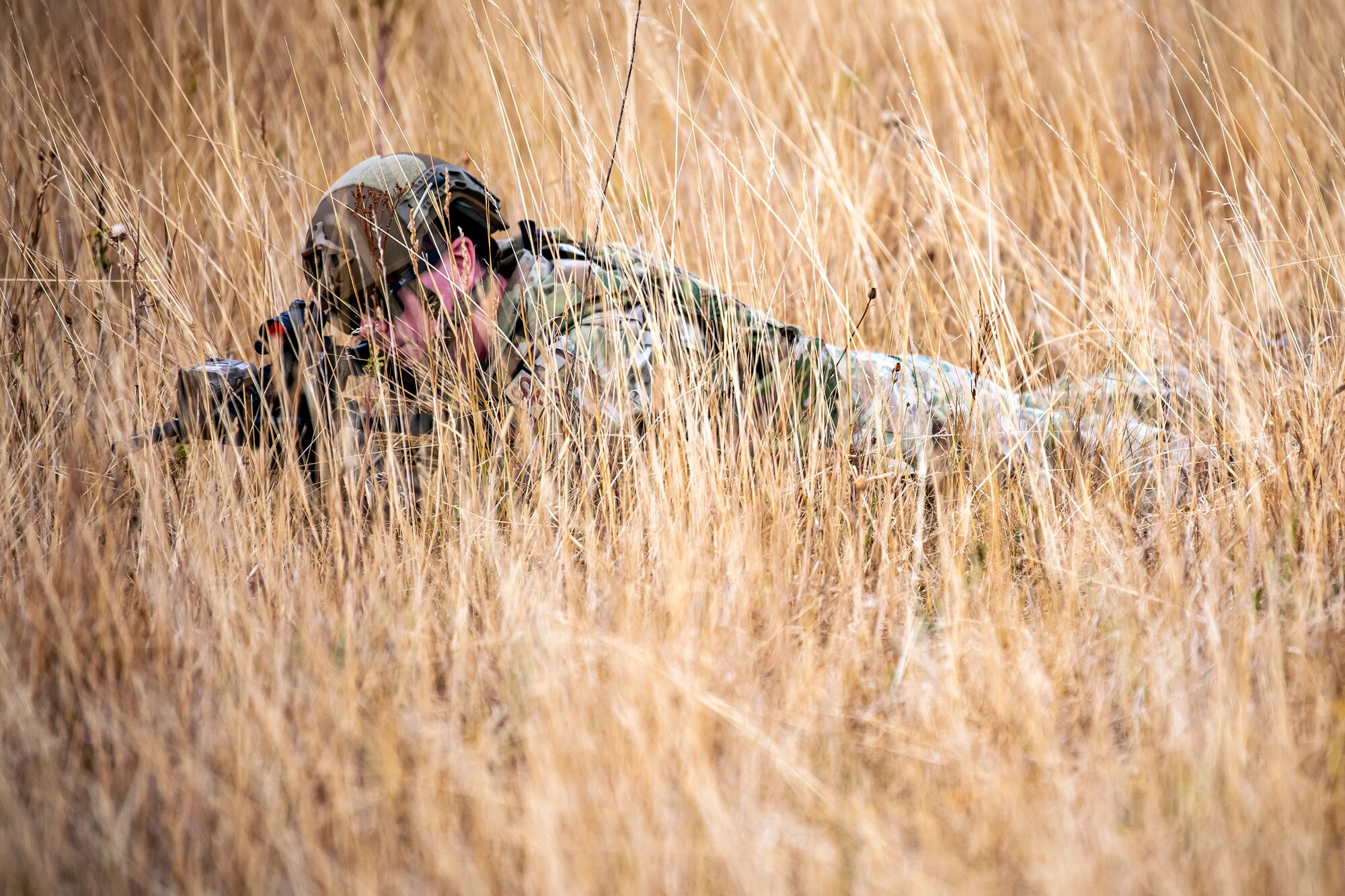 An Airman from the 423d Security Forces Squadron lays prone while looking down the sights of an M4 carbine during a field training exercise at Stanford Training Area, England, Aug. 17, 2022. Instructors from the 820th Base Defense Group and 435th Security Forces Squadron Ground Combat Readiness Training Center, conducted the exercise to evaluate and bolster the combat readiness skills of the defenders from the 423d SFS. (U.S. Air Force photo by Staff Sgt. Eugene Oliver)
