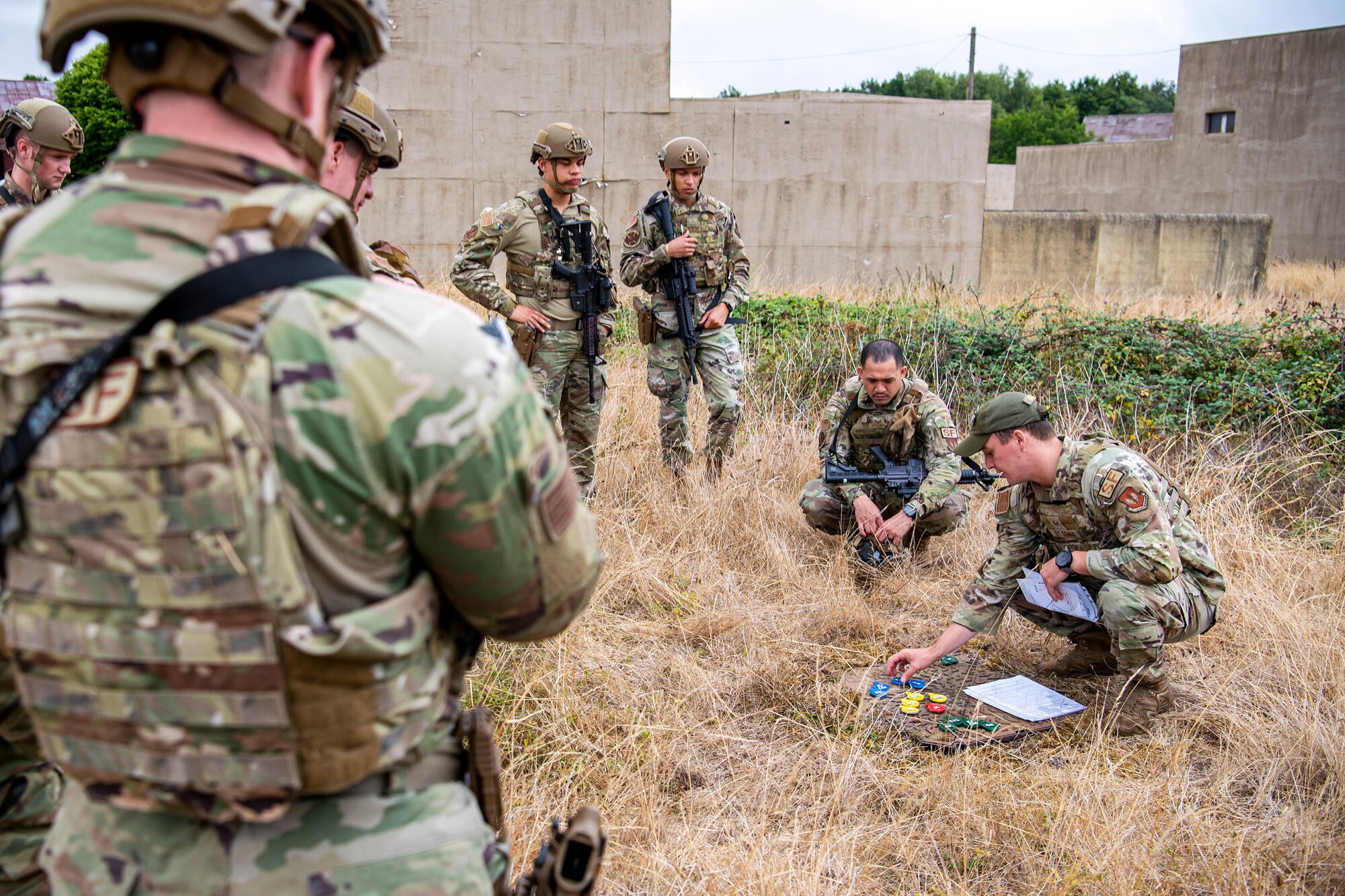 U.S. Air Force Staff Sgt. Matthew St. Denis, 435th Security Forces Squadron Ground Combat Readiness Training Center instructor, demonstrates a wedge formation during a field training exercise at Stanford Training Area, England, Aug. 17, 2022. Instructors from the 820th Base Defense Group and 435th SFSGCRTC, conducted the exercise to evaluate and bolster the combat readiness skills of the defenders from the 423d SFS. (U.S. Air Force photo by Staff Sgt. Eugene Oliver)