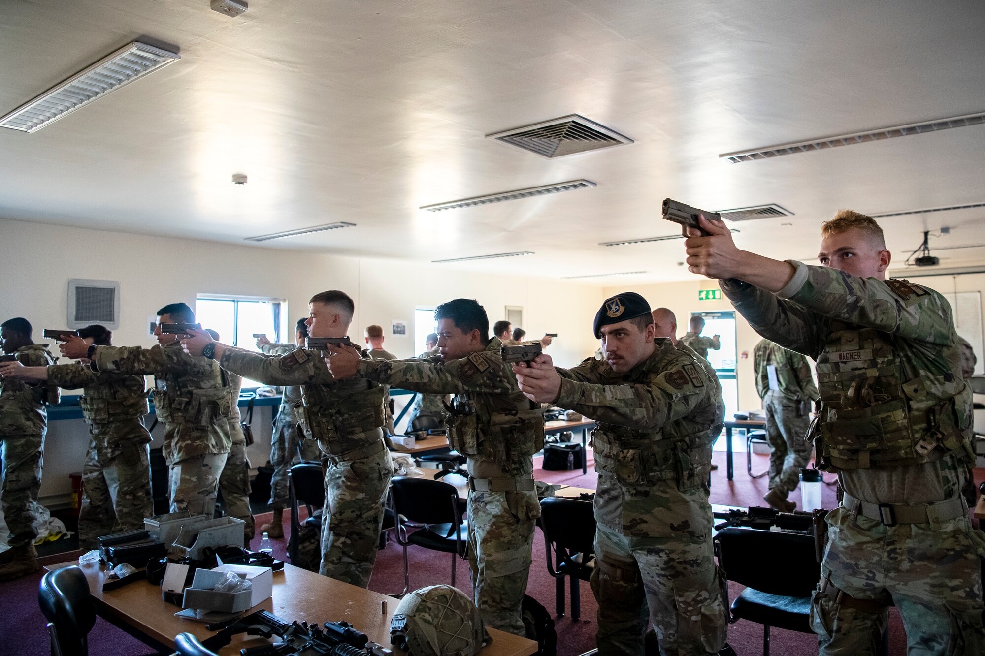 Airmen from the 423d Security Forces Squadron look down the sight of their M18 handguns during a proficiency course at RAF Molesworth, England, Aug. 19, 2022. During the course instructors from the 820th Base Defense Group and 435th Contingency Response Group provided oversight and guidance to help critique and advance the combat arms skills of the defenders from the 423d SFS. (U.S. Air Force photo by Staff Sgt. Eugene Oliver)