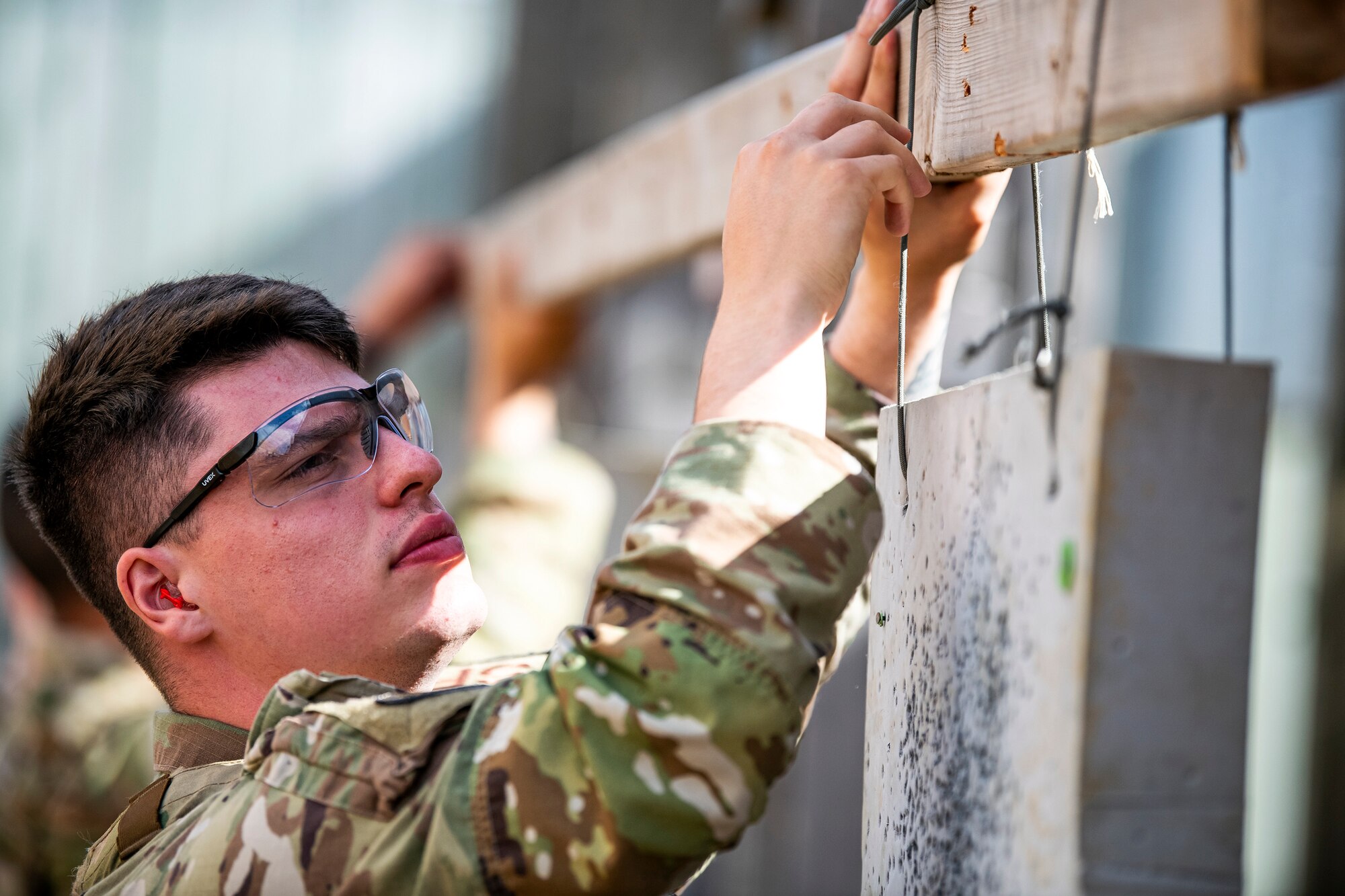 U.S. Air Force Senior Airman Ambrose Ross, 423d Security forces squadron police services, aligns a target sheet during a proficiency course at RAF Molesworth, England, Aug. 19, 2022. During the course instructors from the 820th Base Defense Group and 435th Contingency Response Group provided oversight and guidance to help critique and advance the combat arms skills of the defenders from the 423d SFS. (U.S. Air Force photo by Staff Sgt. Eugene Oliver)