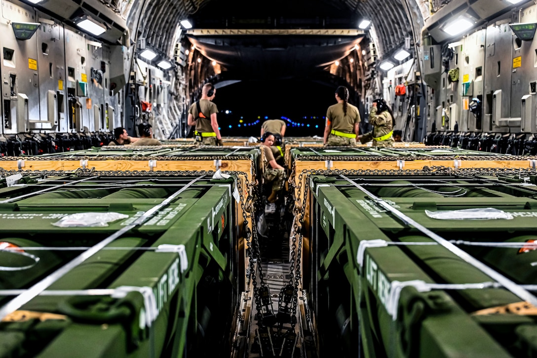 Airmen load munitions onto a plane.