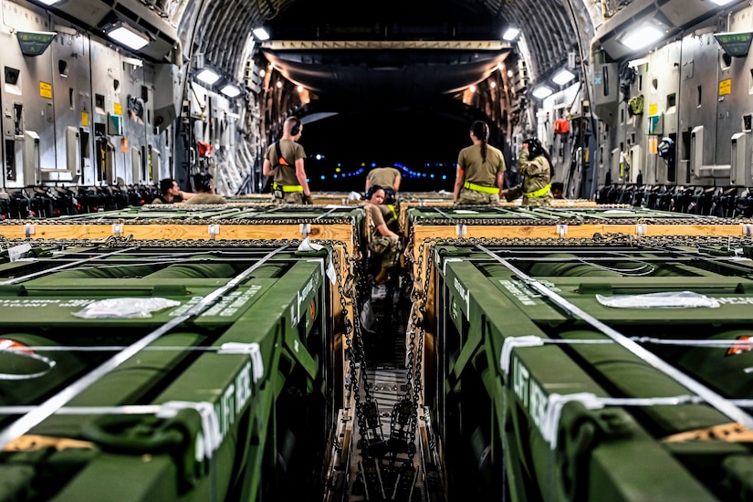 Airmen load munitions onto a plane.