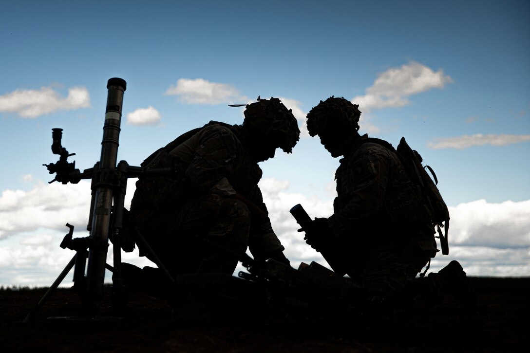 Two soldiers reorganize ammunition after the completion of a fire mission.