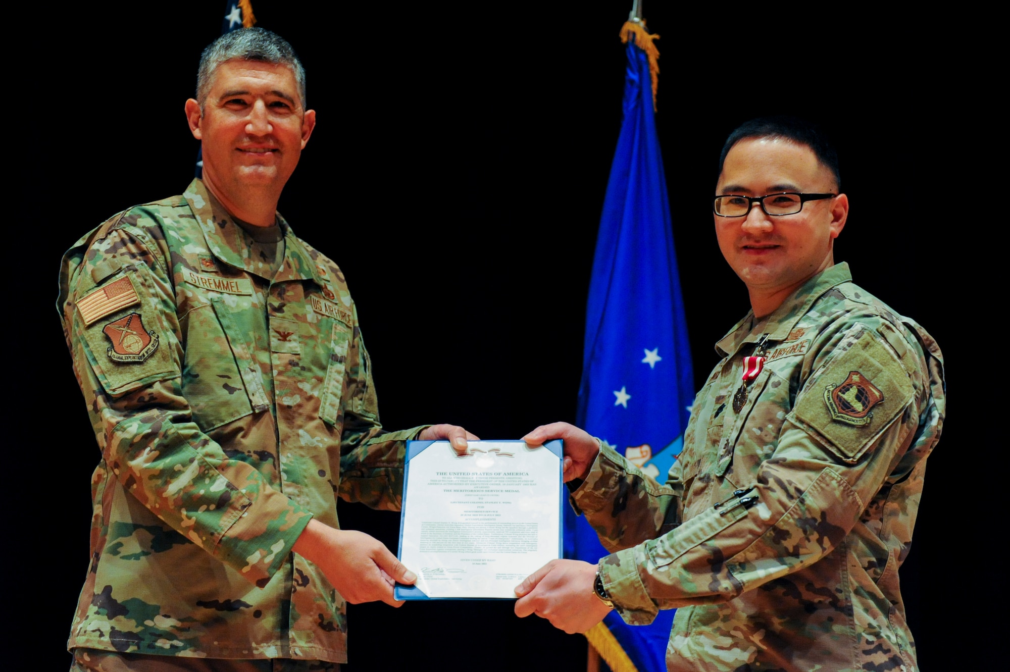 Lt. Col. Stanley Wong, outbound commander of the Global Activities Squadron, accepts a decoration from Col. Kenneth Stremmel, Global Exploitation Intelligence Group commander, during the squadron’s change of command ceremony here, June 21, 2022.  GXA’s mission is to direct, manage, and execute Human Intelligence activities in order to prevent strategic surprise and provide decision advantage to warfighters, defense planners, U.S. Air Force senior leaders and policy makers. (U.S. Air Force photo by Senior Airman Kristof J. Rixmann)