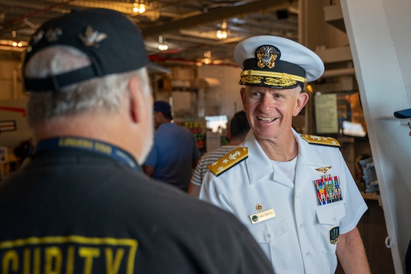 Vice Adm. Daniel Dwyer, commander, U.S. 2nd Fleet, greets visitors, volunteers, workers aboard the USS Hornet Sea, Air and Space Museum during the 100th Anniversary of the Aircraft Carrier ceremony in Alameda, Calif., August 13.