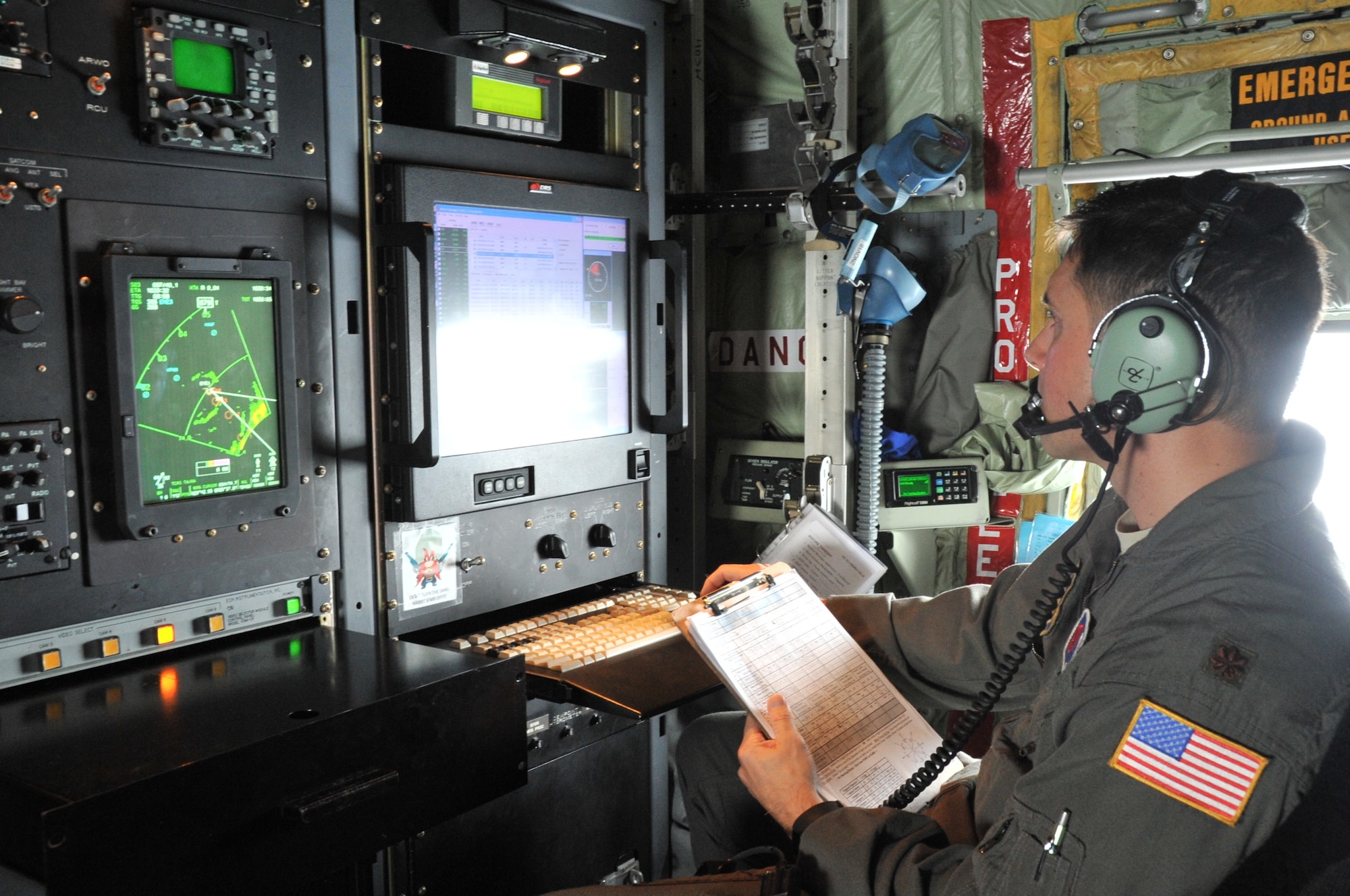 A weather officer looks at screens inside an aircraft.